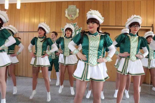 Tanzgarde der GOK 1906 e.V. in grün-weißen Uniformen steht in Formation in einem holzvertäfelten Saal bereit zur Aufführung.